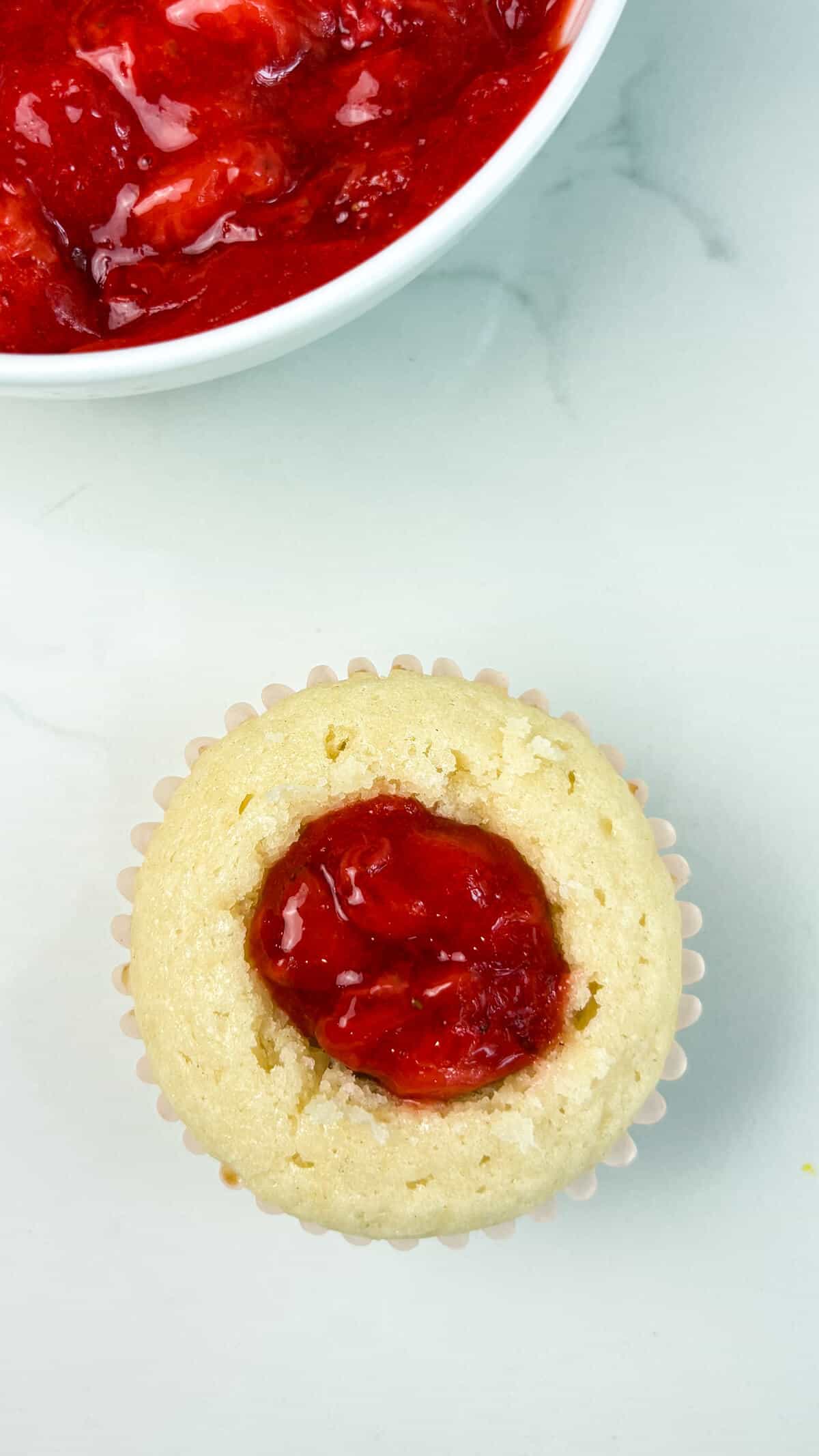 Cupcake filled with fresh strawberry compote.