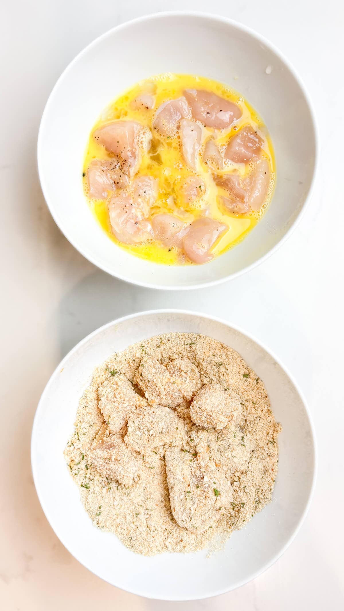 Chopped chicken dipped in egg and then breadcrumbs before cooking.